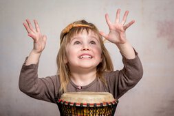 Kind spielt Trommel währen Musiktherapie | © shutterstock-tatyana-vyc